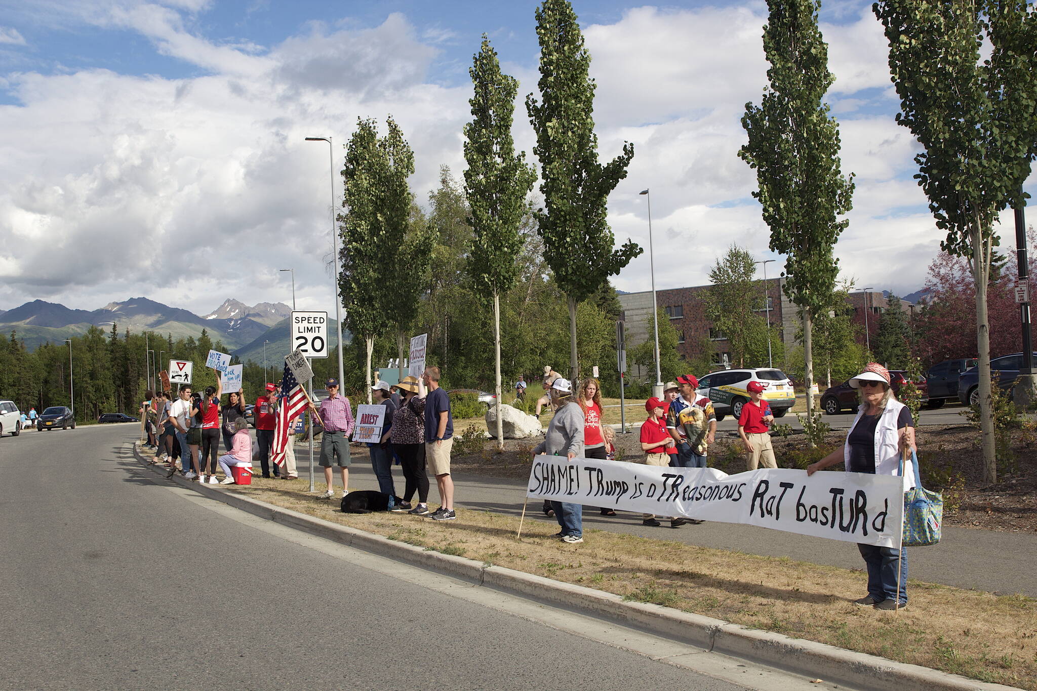 Anti-Trump protesters across the street from the Alaska Airlines Center in Anchorage wave signs at people departing the Save America Rally on Saturday. (Mark Sabbatini / Juneau Empire)