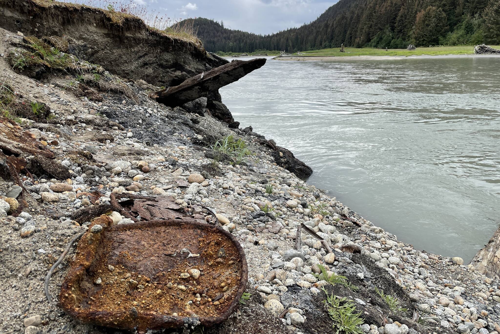 Rusted oil barrels are visible on the riverbank of the Eagle River as erosion exposes more debris from roadbuilding infrastructure buried decades. (Michael S. Lockett / Juneau Empire)