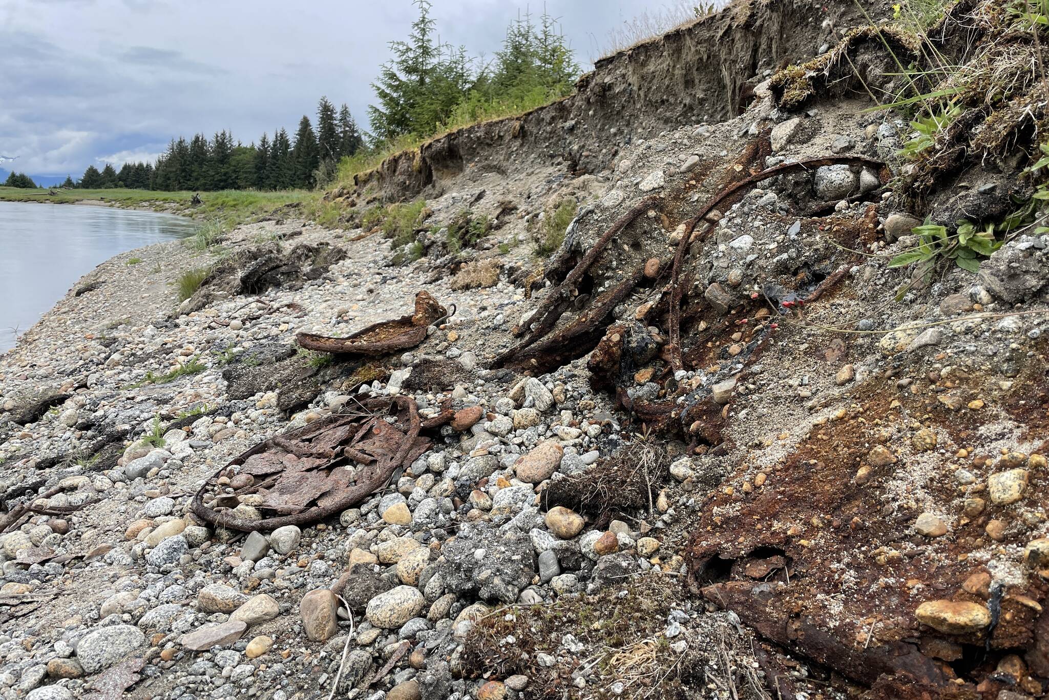 Rusted debris from oil cans and other waste on the riverbank of the Eagle River as erosion exposes more debris from roadbuilding infrastructure buried decades. (Michael S. Lockett / Juneau Empire)