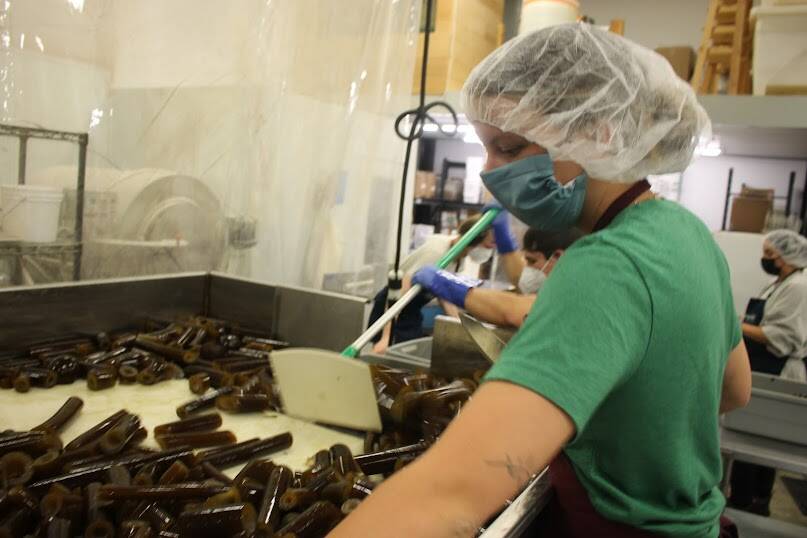 Clarise Larson / Juneau Empire
Barnacle Foods employees use large knives to chop up bull kelp as it makes it was down the conveyor belt.