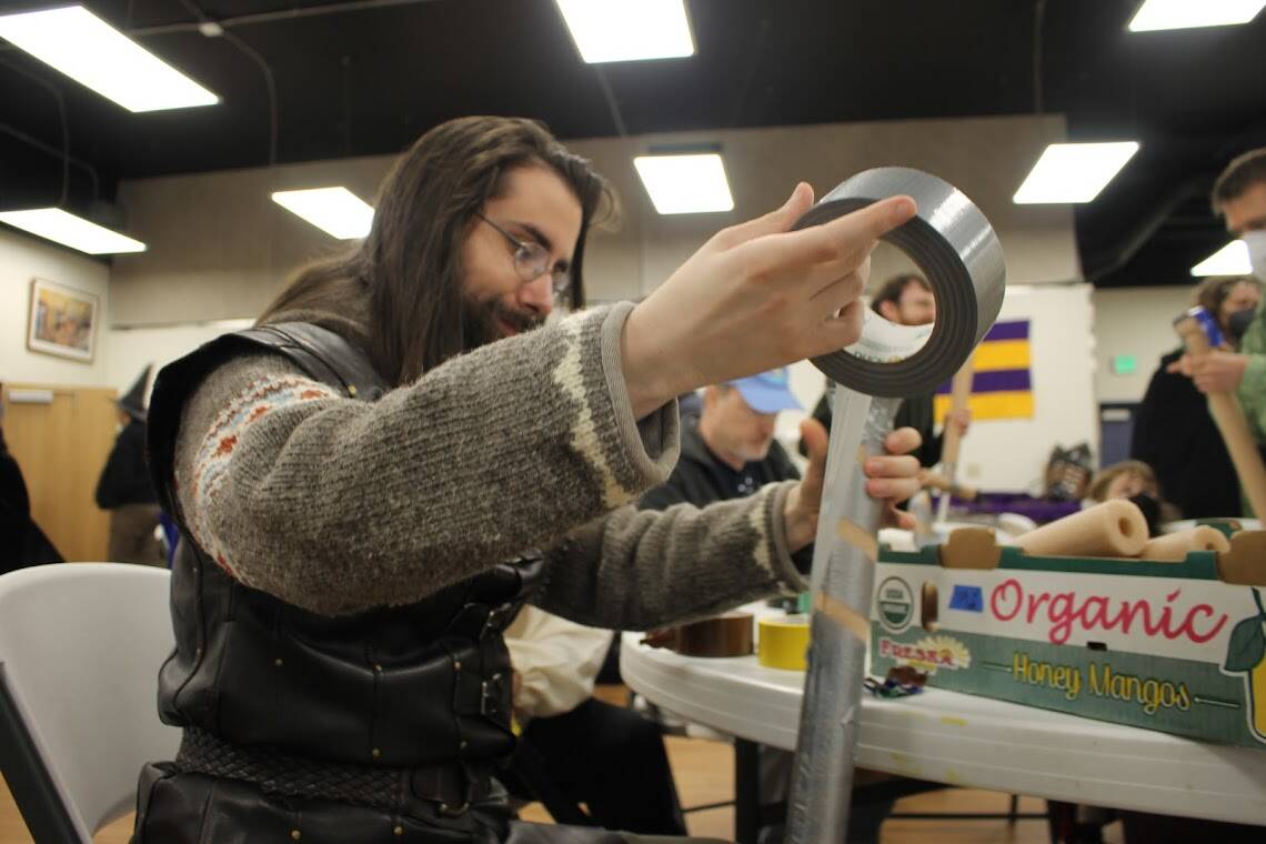 Amtgard of Alaska member Liam Porter-Bell finishes wrapping his “sword” with duct tape before heading for battle.(Clarise Larson // Juneau Empire)