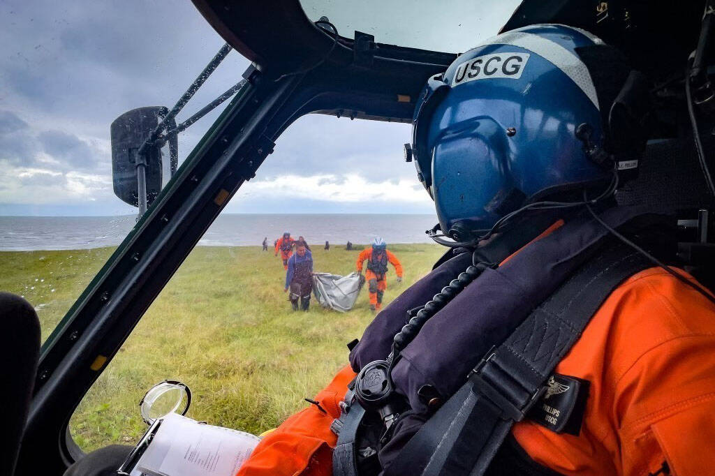 A Coast Guard Air Station Kodiak MH-60 Jayhawk helicopter pilot watches as the aircrew assists overdue boaters, July 18, 2022. (Lt. Scott Kellerman / U.S. Coast Guard)