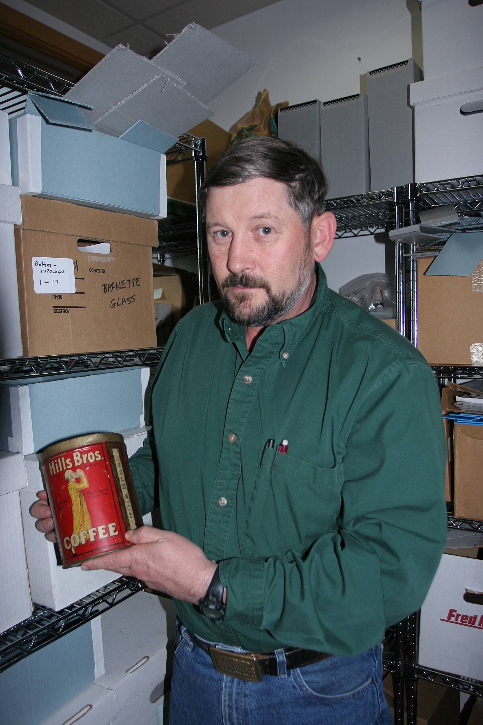Steve Lanford holds a well-preserved Hills Brothers coffee can recovered from an historic site on public lands in Alaska. The company made numerous small changes to the label over the years, so archeologists utilizing a guide book can determine the age of cans they find. (Courtesy Photo / Craig McCaa,BLM.