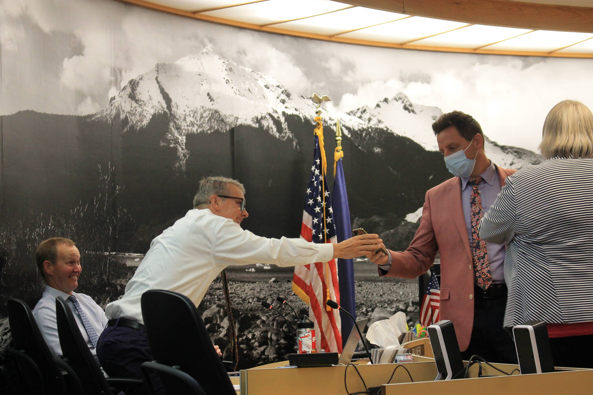 City Manager Rorie Watt chats with member of the Assembly during a break in Monday night’s meeting. (Clarise Larson/ Juneau Empire)