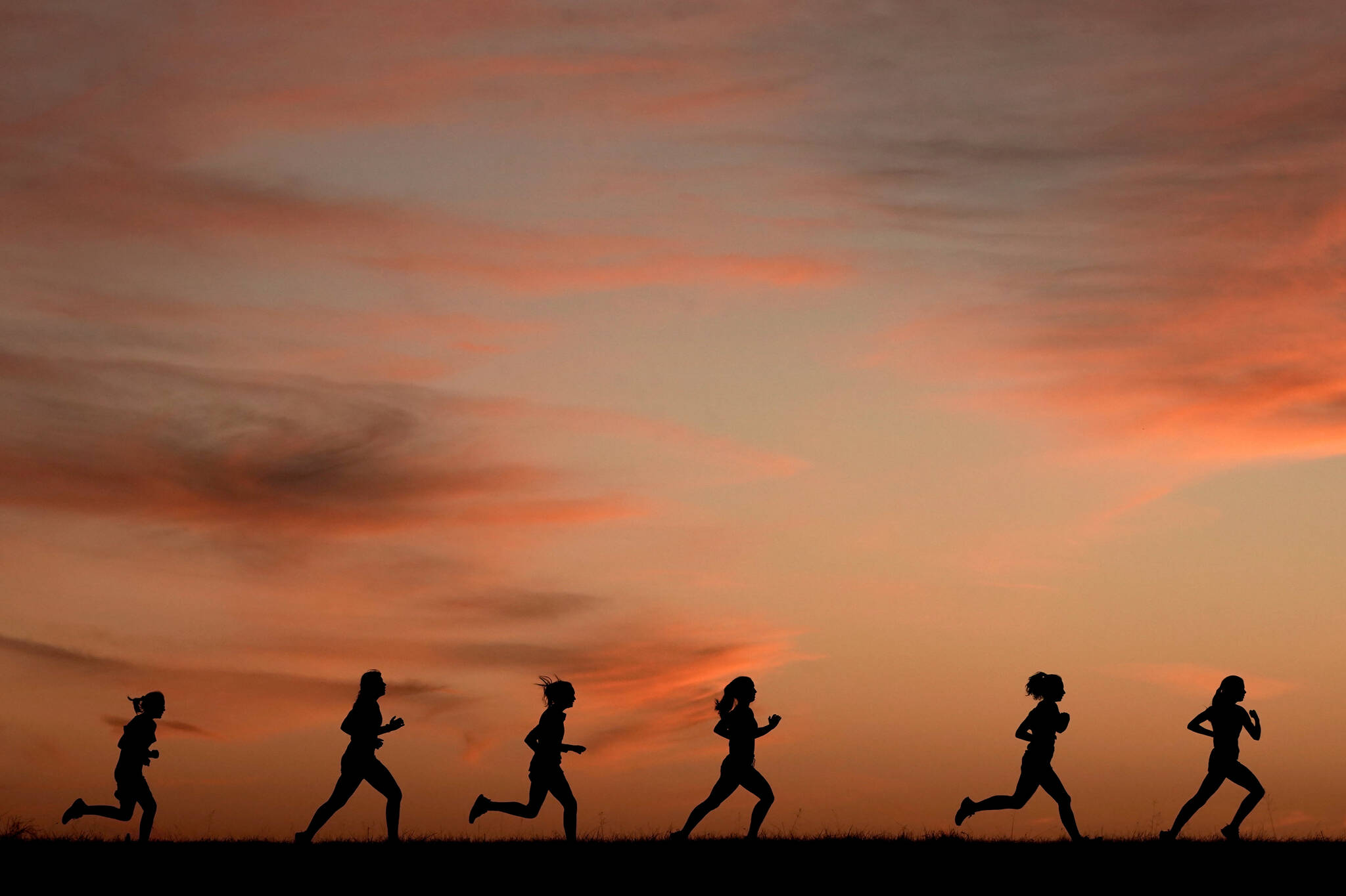 High school students run at sunset as they practice for the track and field season Monday, Feb. 28, 2022, in Shawnee, Kan. New research hints that even simple exercise just might help fend off memory problems. While physical activity helps keep healthy brains fit, it’s not clear how much it helps once memory starts to slide. (AP Photo / Charlie Riedel)