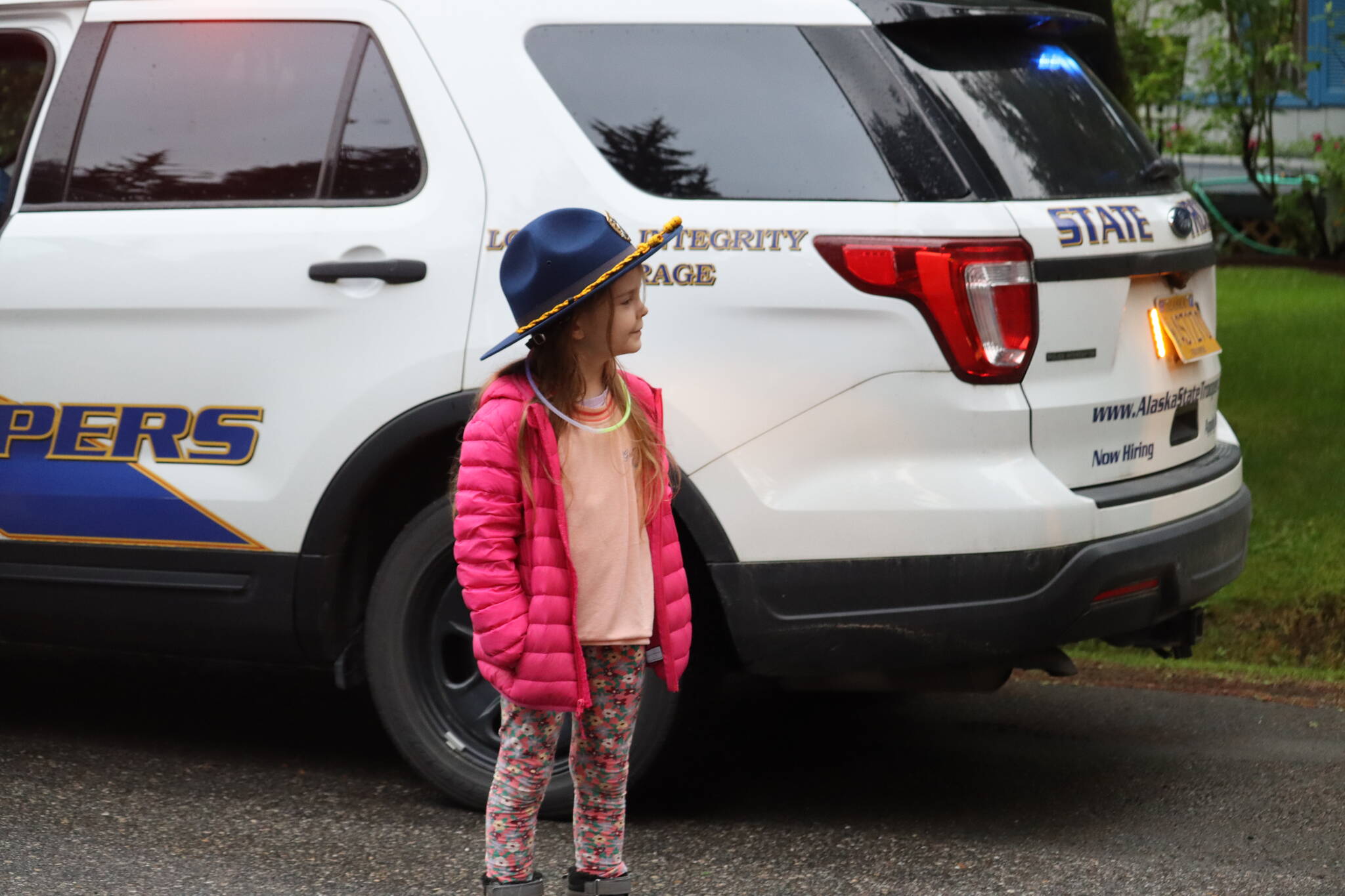 Emily Gouk trying on Alaska State Trooper hat at Juneau’s 14th annual National Night Out. A main focus of the national event is community engagement, but especially amongst children. Photo taken on Skywood Lane. (Jonson Kuhn / Juneau Empire)