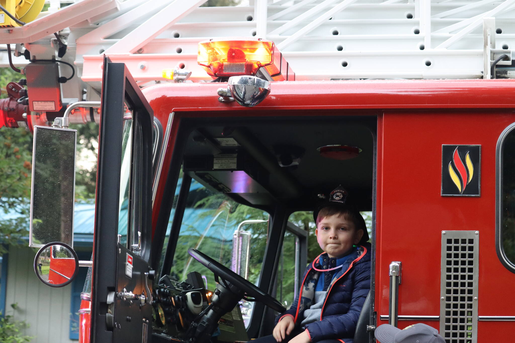 Thomas Gouk poses for photos while seated in the driver’s seat of Capital City Fire/ Rescue’s emergency vehicle. Photo was taken on Skywood Lane. (Jonson Kuhn / Juneau Empire)