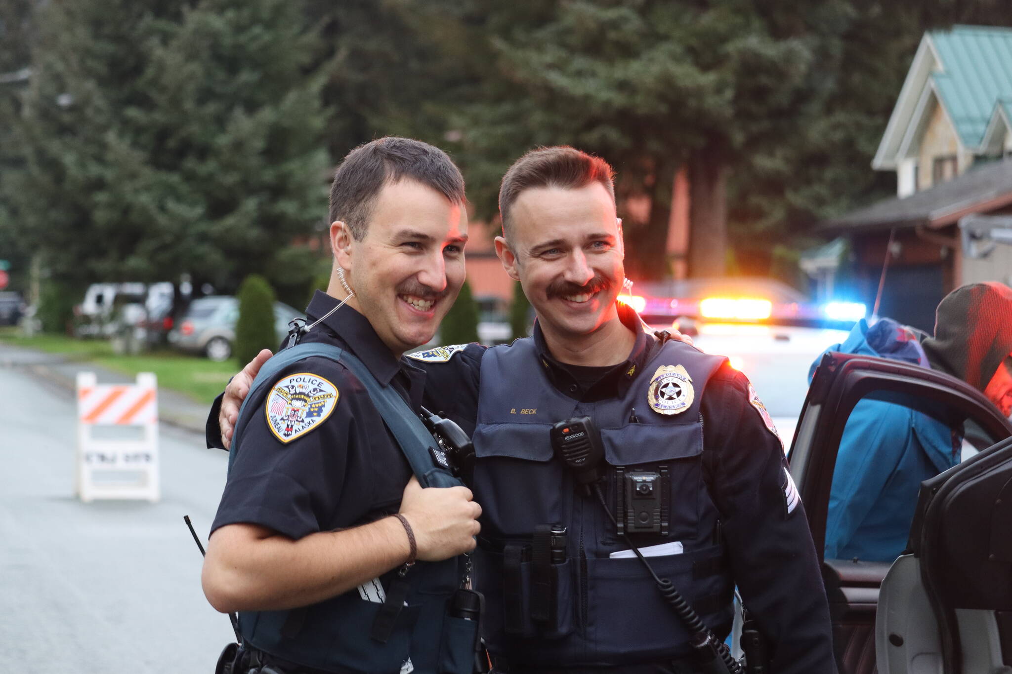 Juneau Police Officers Beckett Savage and Ben Beck pose together for a photo op taken on Rivercourt Street during National Night Out on Tuesday, Aug. 2.