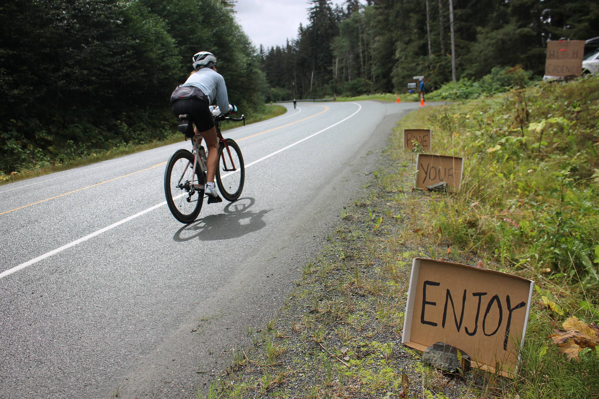 A set of motivational signs line Glacier Highway for racers to view. (Clarise Larson/ Juneau Empire)