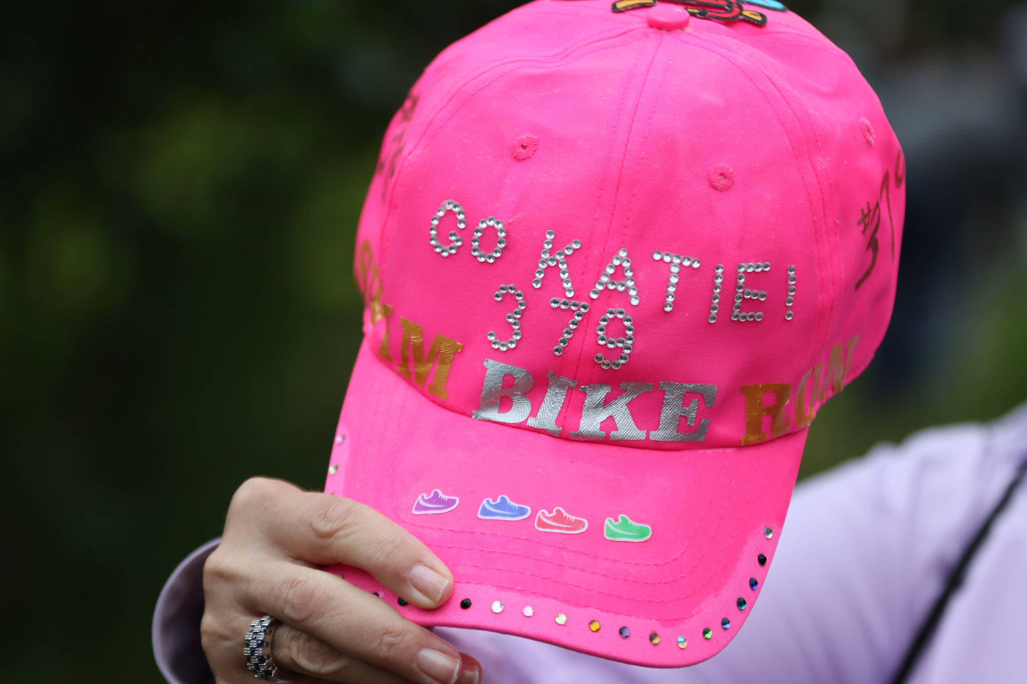 Claire Dysarczyk holds up a custom pink cap made to support Katie Zlotecki. Dysarczyk and several others traveled to Juneau from Michigan for the event and came with flamboyant, bedazzled gear. (Ben Hohenstatt / Juneau Empire)