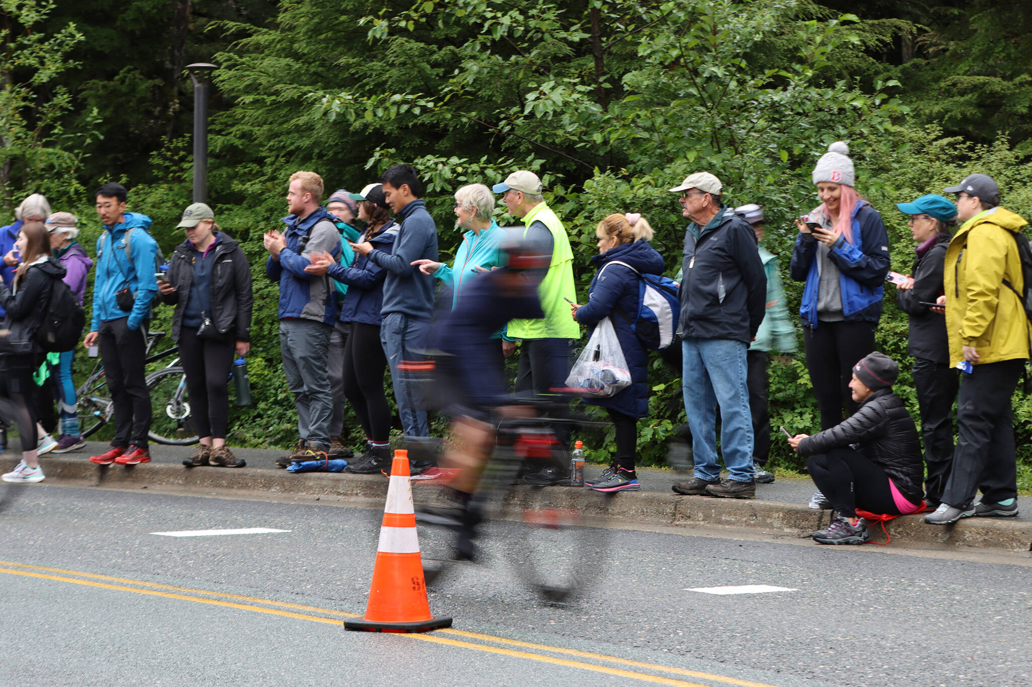 A cyclist moves past a throng of spectators during Ironman Alaska. (Ben Hohenstatt / Juneau Empire)