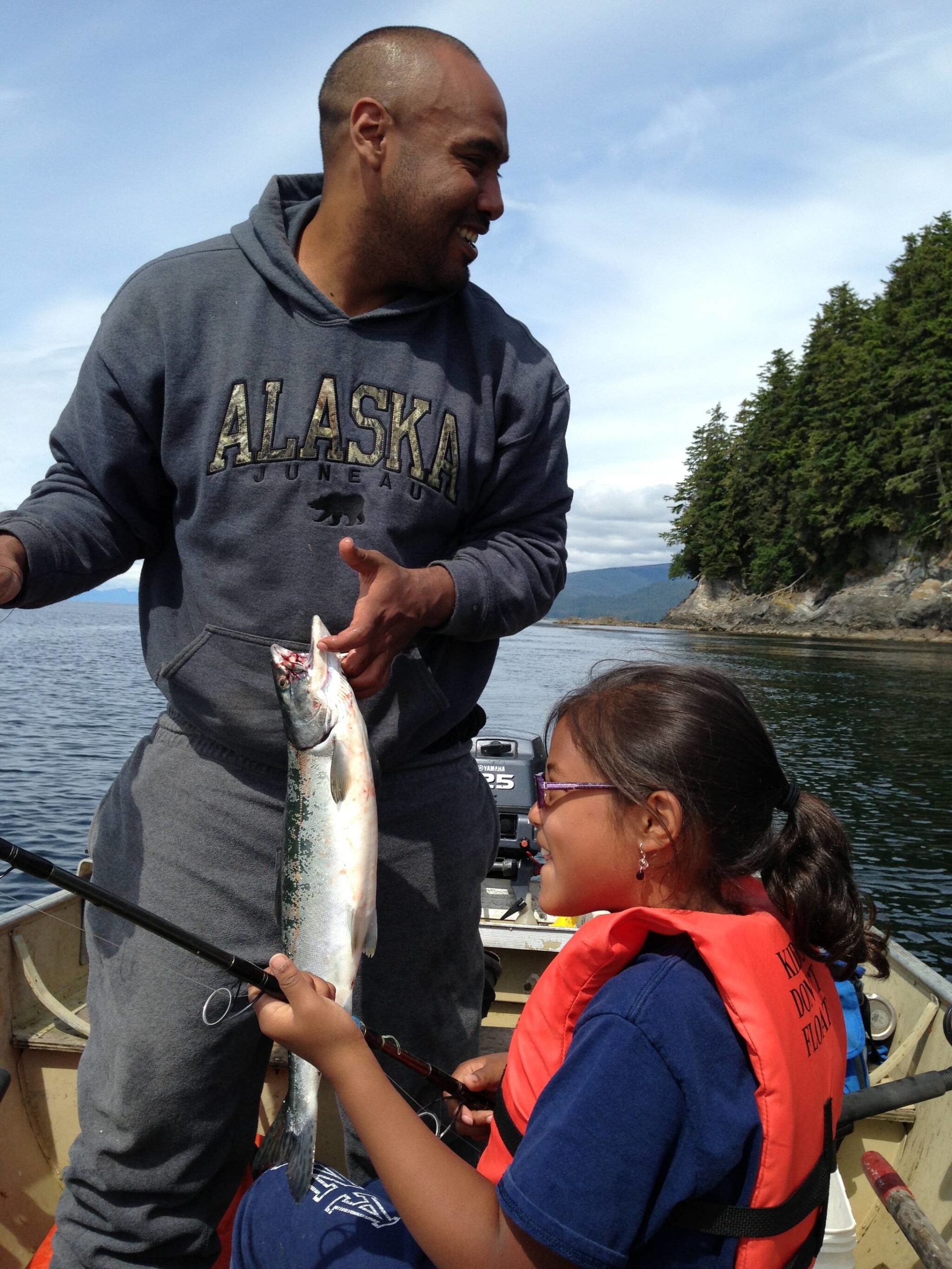 This is a photo of a young Gabrielle Shaawatgoox George-Frank and her father Jason Frank smile together after catching a fish ear Angoon, Alaska where her family originates from. George-Frank said her father and Alaskan Native family’s lifestyle inspired her love for nature. (Courtesy Photo / Gabrielle Shaawatgoox George-Frank)