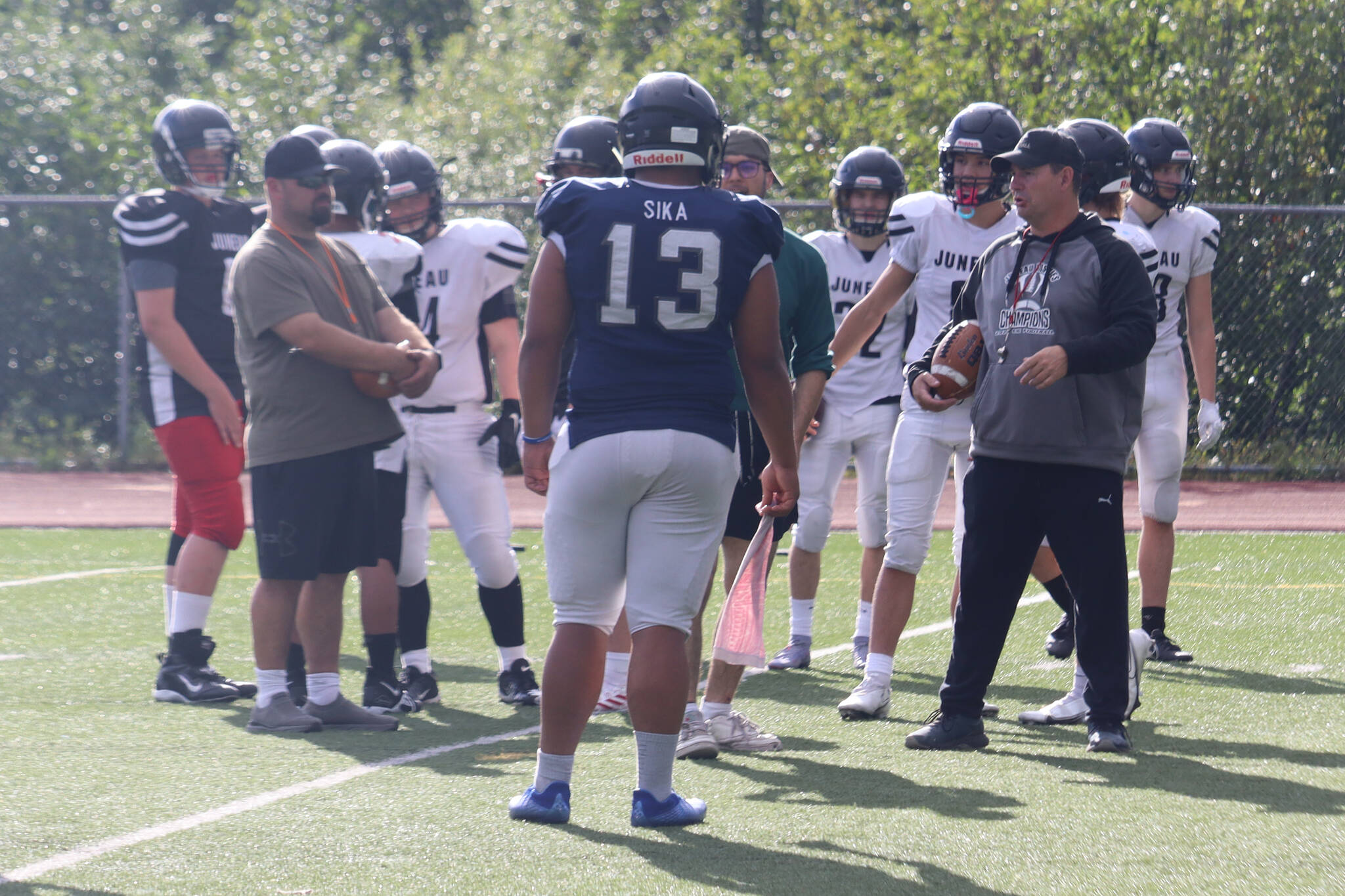 Juneau senior Sam Sika is seen in this photo joining the huddle for coach Sjoroos’ pep talk during practice. Sika and the rest of Huskies defense came up big on Saturday’s season opener against the Dimond Lynx in Anchorage. (Jonson Kuhn / Juneau Empire)