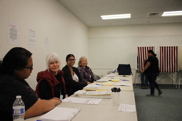Election official sit by the polling booths at the Mendenhall Mall precinct to help voters with any questions or confusion for this year’s elections for Alaska’s open U.S. House seat and a pick-one primary for U.S. Senate. (Clarise Larson / Juneau Empire)
