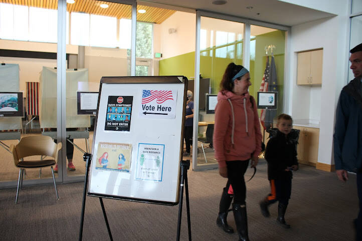 A family walks out of the Mendenhall Valley Public Library after casting their ballots on this year’s Election Day for the special general election and a regular primary election. (Clarise Larson / Juneau Empire)
