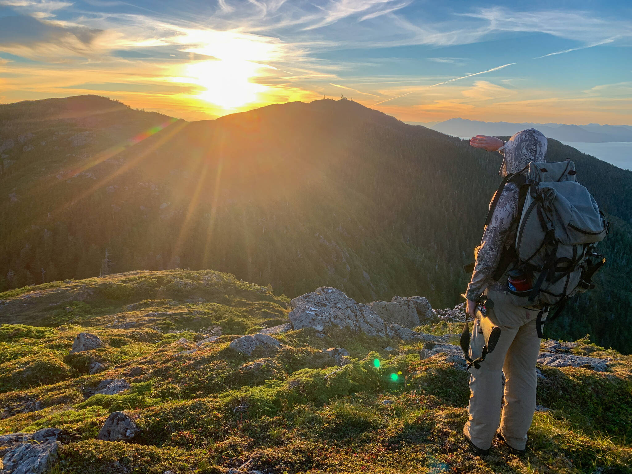 The author looks over a mountain near Ketchikan in the late evening sun on an alpine deer hunt. (Courtesy Photo / Abby Lund)