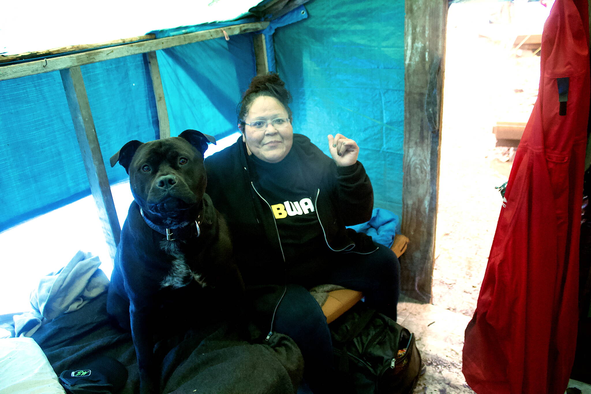 Mark Sabbatini / Juneau Empire
Shelly Stevens, a Juneau resident since 1985 whos been homeless since 2012, dries out in her tent during a heavy rainstorm Monday at Mill Campground alongside Raider, the communal bear dog for the 20-platform campsite for the homeless. Stevens said she has been alternating between the campground during warmer months and the city-sponsored warming shelter during the winter due to her struggles with alcohol and marijuana addiction.