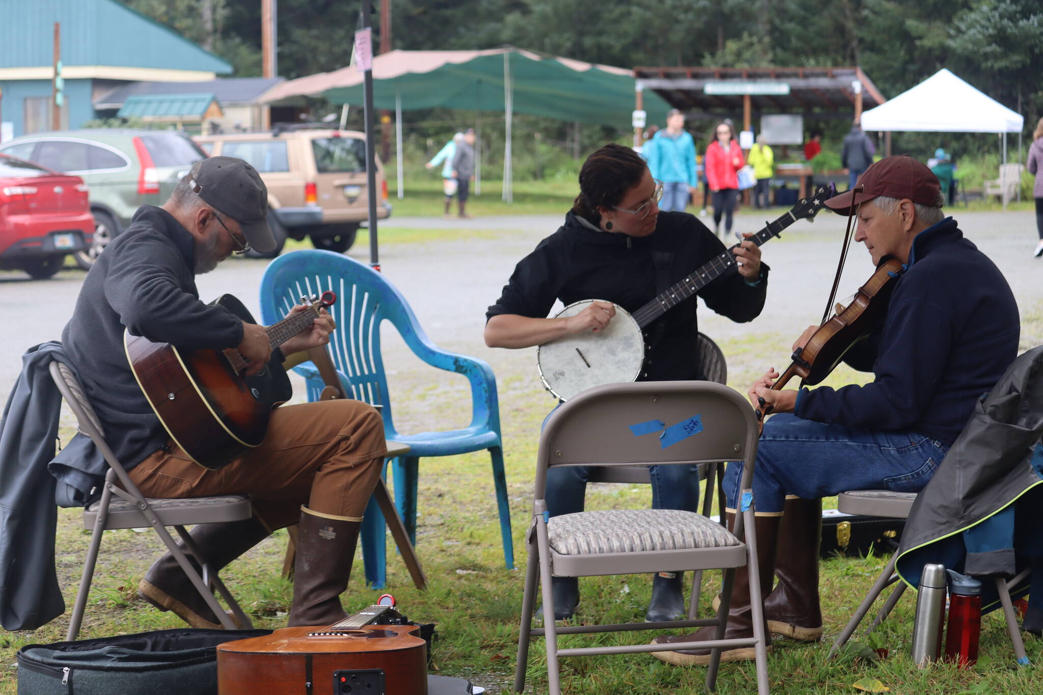 From left to right, Chris Mead on guitar, Devin Tatro on banjo, and Tom Paul on fiddle provided hours of music on Saturday for the 28th Annual Harvest Fair on Saturday. (Jonson Kuhn / Juneau Empire)