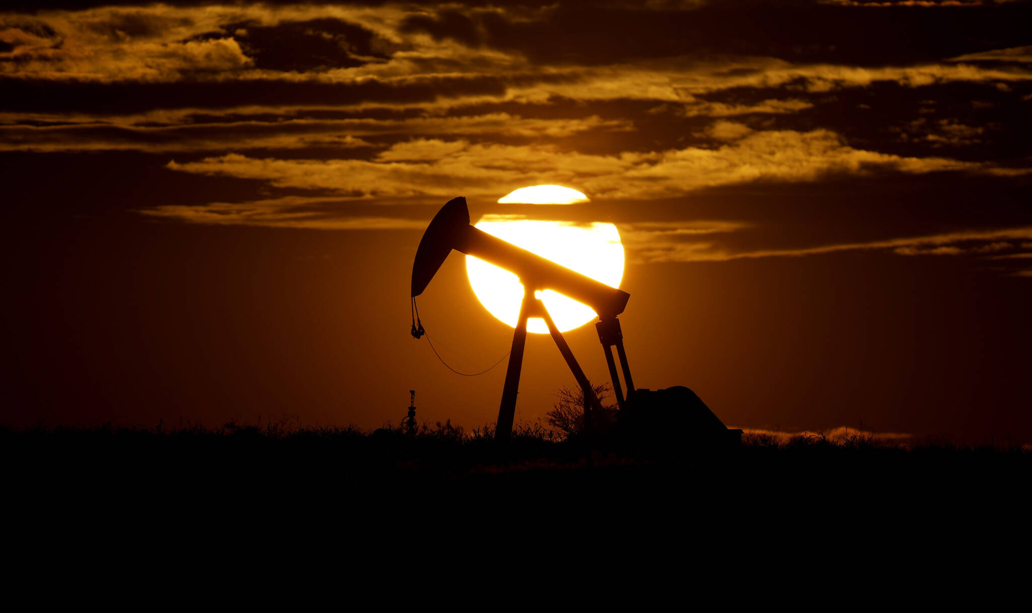 The sun sets behind an idle pump jack near Karnes City, USA, April 8, 2020. Oil prices are sagging amid fears of recessions across the globe. OPEC and allied countries are weighing what to do about that when they meet online Thursday, Sept. 8, 2022. High oil prices were a bonanza for countries like Saudi Arabia over the summer, but now they’re well off those highs. Saudi Arabia’s oil minister has even said the group known as OPEC+ could cut production at any time. (AP Photo / Eric Gay)