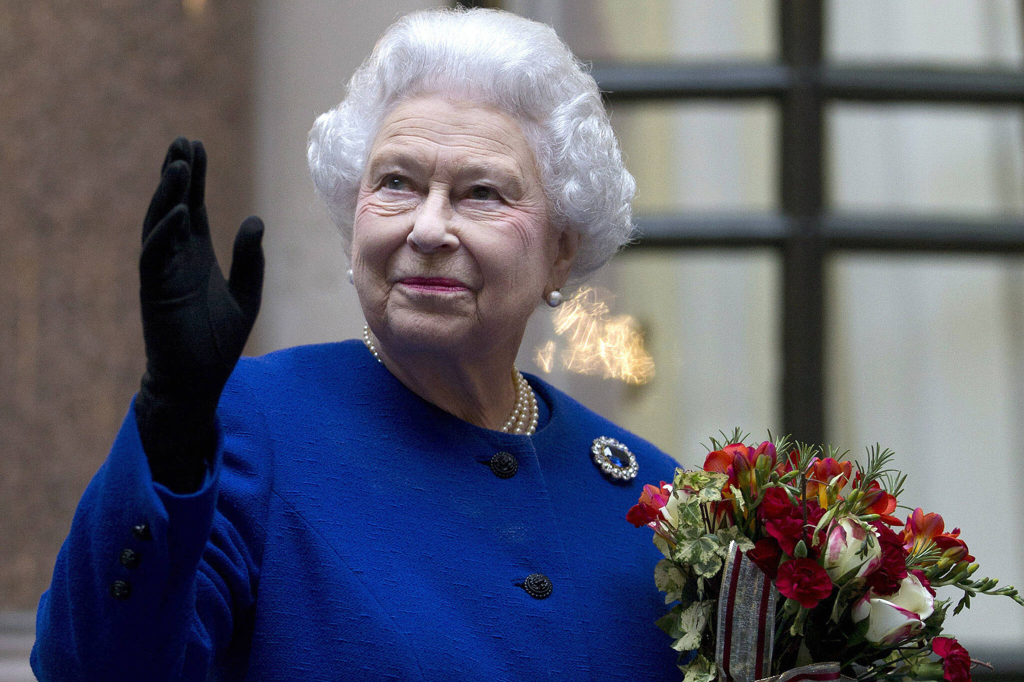 In this Tuesday, Dec. 18, 2012 file photo, Britain's Queen Elizabeth II looks up and waves to members of staff of The Foreign and Commonwealth Office as she ends an official visit which is part of her Jubilee celebrations in London. Queen Elizabeth II, Britain’s longest-reigning monarch and a symbol of stability across much of a turbulent century, has died on Thursday, Sept, 8, 2022. She was 96. (AP Photo / Alastair Grant Pool)