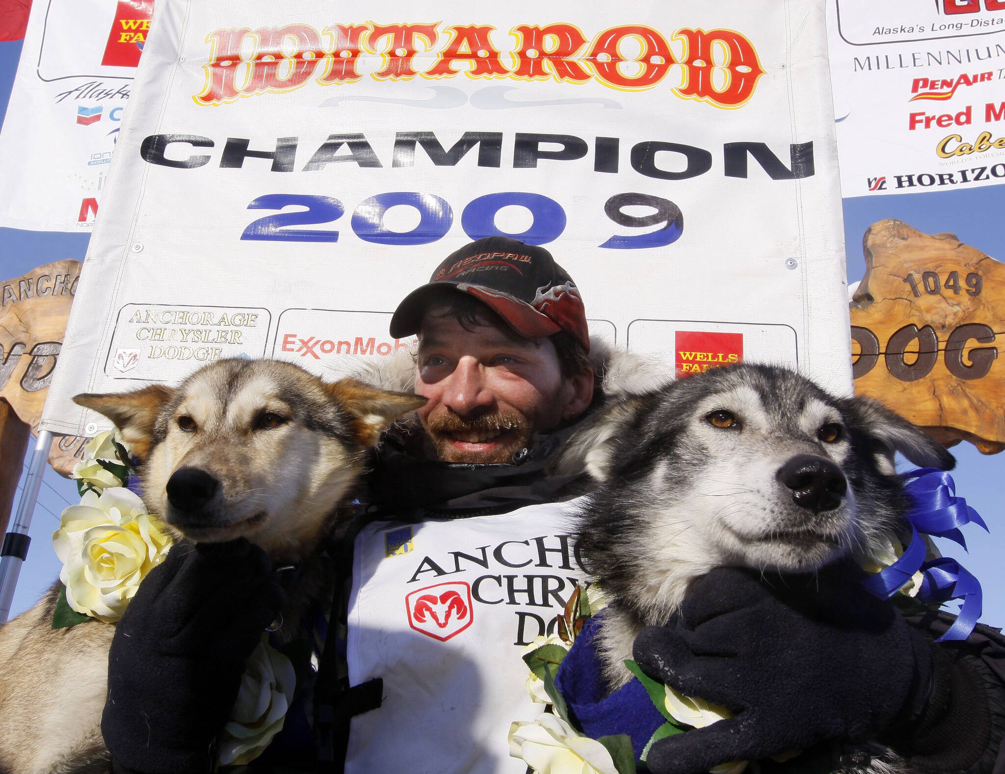 Lance Mackey sits with his lead dogs Larry, right, and Maple after crossing the finish line of the Iditarod Trail Sled Dog Race on March 18, 2009, in Nome, Alaska, to win his third Iditarod in a row. Mackey, a four-time Iditarod Trail Sled Dog Race winner and one of mushing’s most colorful and accomplished champions who also suffered from health and drug issues, died Wednesday, Sept. 7, 2022, his father and kennel announced on Facebook. He was 52. (AP Photo/Al Grillo, File)