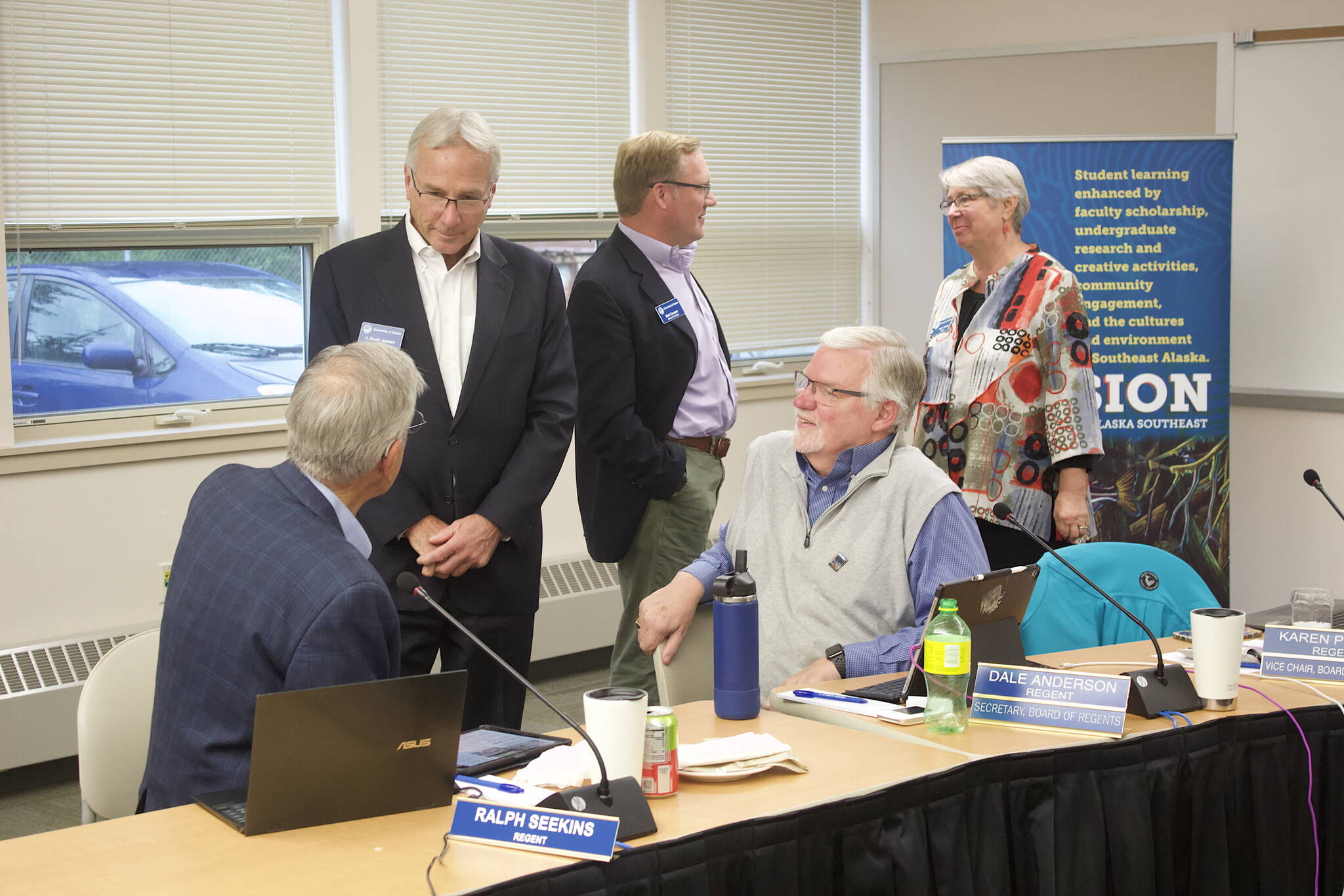 Members of the University of Alaska’s Board of Regents chat during a break in their meeting Thursday at the University of Alaska Southeast. (Mark Sabbatini / Juneau Empire)