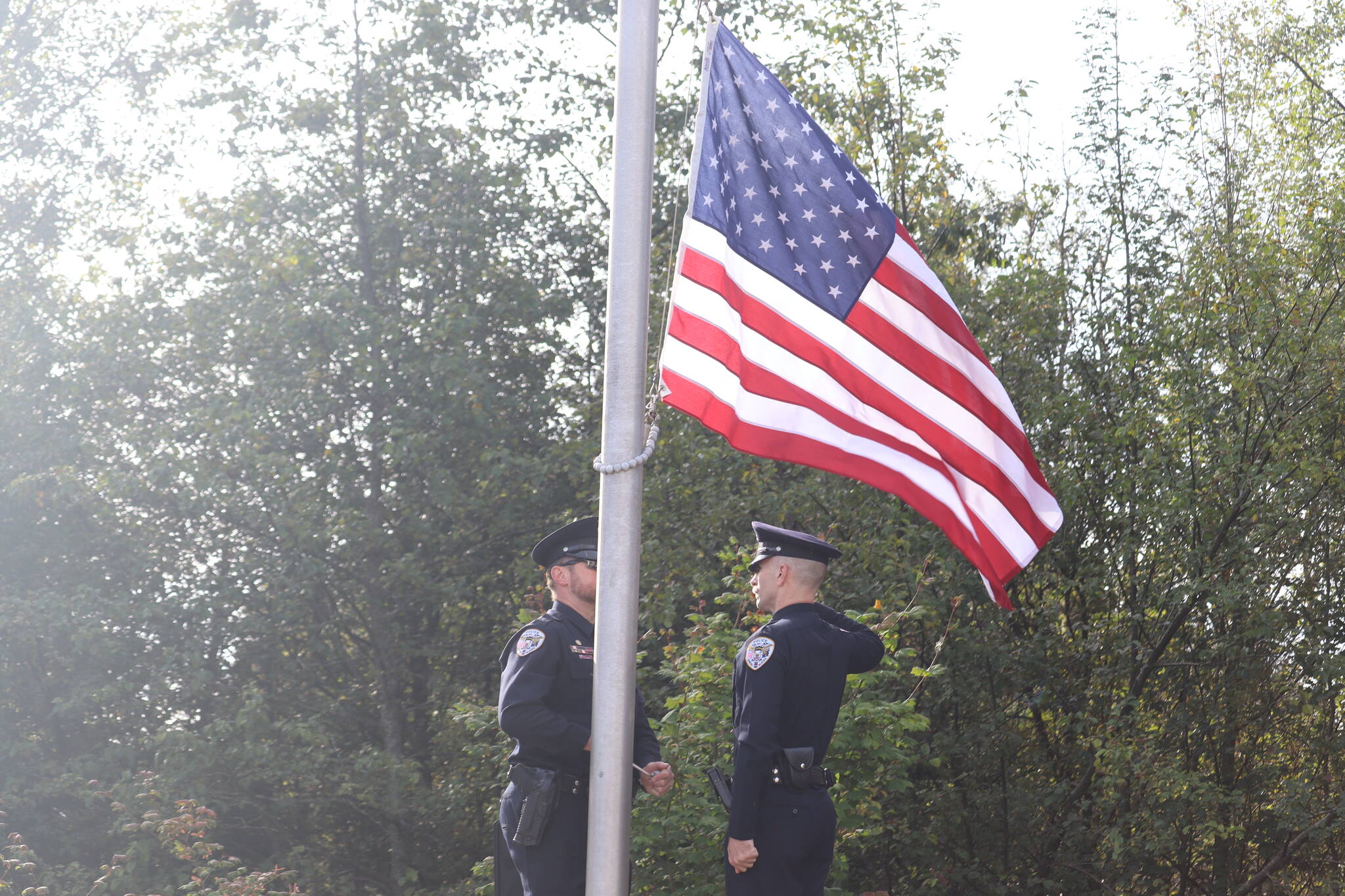 Juneau Police Department officers raised the flag at half mast at 9:58 a.m. on Sunday morning, as a way of remembering the exact time that the first plane struck the first World Trade Tower in New York on Sept. 11, 2001. (Jonson Kuhn / Juneau Empire)