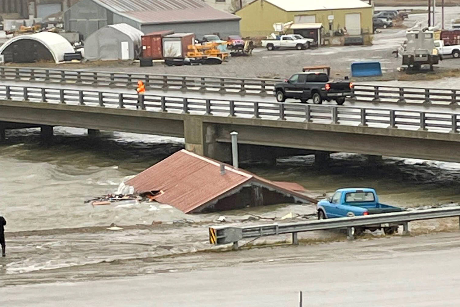 A home that was knocked off its foundation and floated down Snake River during a severe storm in Nome, Alaska, is caught under a bridge Saturday, Sept. 17, 2022. Much of Alaska’s western coast was battered by the storm, which was the remnant of Typhoon Merbok, causing the most damage of any storm in the last half century. (AP Photo/Peggy Fagerstrom)