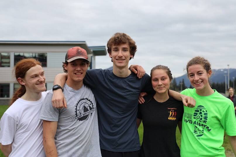 From left to right, Thunder Mountain High School senior cross country runners Michael Wittig, Justus Paden, Ben Erickson, Aliyah Overturf and Mackenzie Olver smile for picture after cross country practice on Monday afternoon. (Clarise Larson / Juneau Empire)