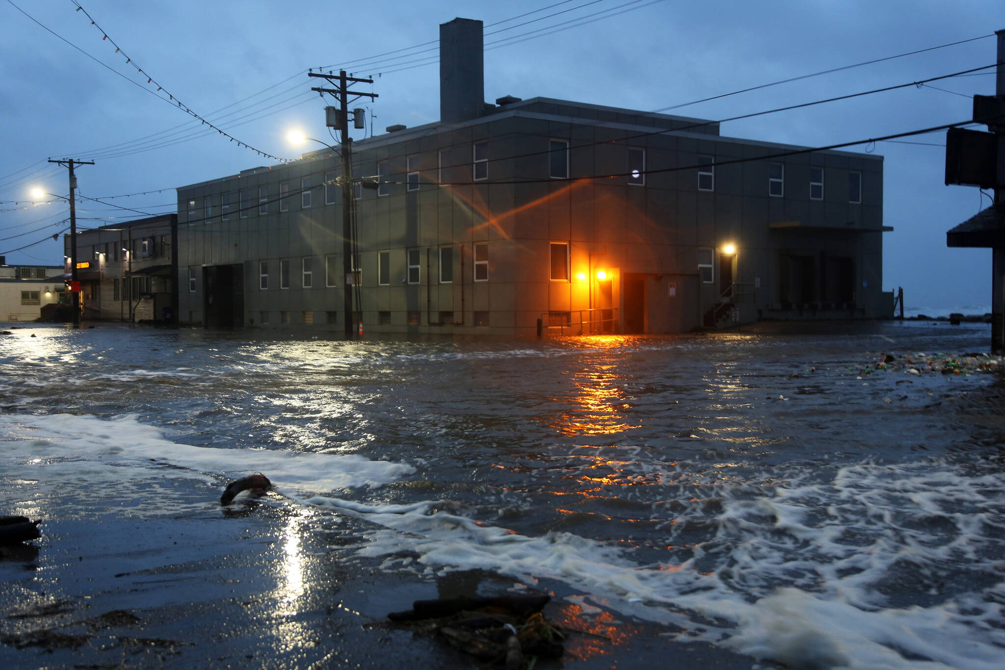 Water rushes down Front Street, just a half block from the Bering Sea, in Nome, Alaska, on Saturday, Sept. 17, 2022 as the remnants of Typhoon Merbok moved into the region. It was a massive storm system — big enough to cover the mainland U.S. from the Pacific Ocean to Nebraska and from Canada to Texas. It influenced weather systems as far away as California, where a rare late-summer storm dropped rain on the northern part of the state, offering a measure of relief to wildfire crews but also complicating fire suppression efforts because of mud and loosened earth. (AP Photo / Peggy Fagerstrom)