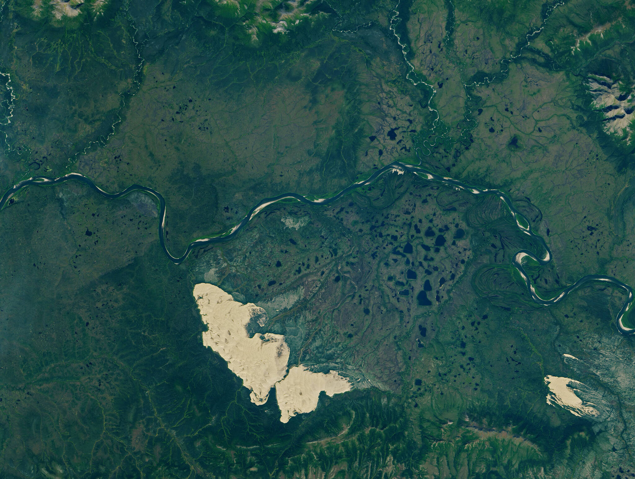 The Kobuk Sand Dunes, left, Little Kobuk Sand Dunes and the Kobuk River in northwestern Alaska as seen from space on Aug. 16, 2020. NASA Earth Observatory image by Lauren Dauphin, using Landsat data from the U.S. Geological Survey.