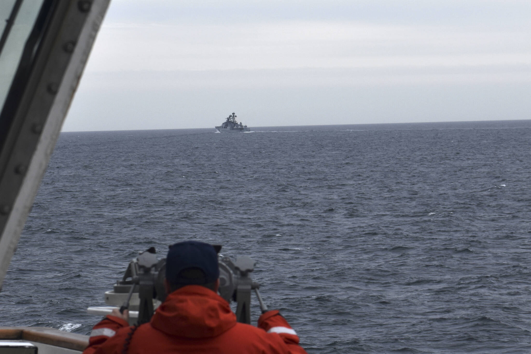 In this photo provided by the U.S. Coast Guard, a Coast Guard Cutter Kimball crew-member observes a foreign vessel in the Bering Sea, Monday, Sept. 19, 2022. The U.S. Coast Guard cutter on routine patrol in the Bering Sea came across the guided missile cruiser from the People's Republic of China, officials said Monday, Sept. 26.  (U.S. Coast Guard District 17 via AP)