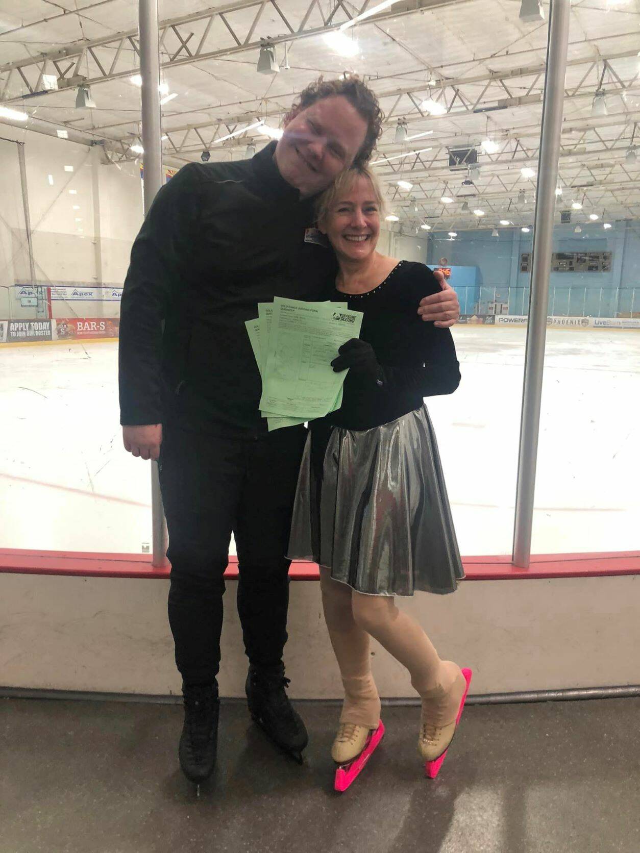 Wendy Vuille poses with American ice dancer and two-time alternate for the Olympic Games, Todd Gilles. Gilles partnered with Vuille at the Arizona Adult Skating Camp where she passed her Masters Gold Dance with the United States Figure Skating Association. Vuille in this photo is holding the judges forms shortly after passing her gold medalist in ice dance. (Courtesy Photo / Wendy Vuille)