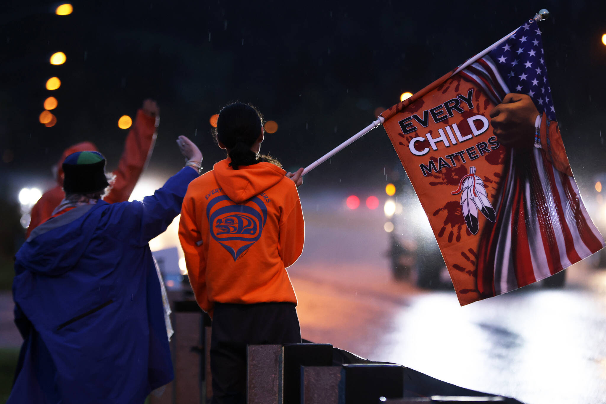 Keagan Hasselquist, 15, holds up a flag bearing the message “Every child matters” during an Orange Shirt Day event Friday morning in Juneau. The event started at 6:45 a.m. Hasselquist said he usually isn’t out and about at that time “but I’m doing good with it so far.” He said it was awesome to see strong turnout for the event. (Ben Hohenstatt / Juneau Empire)