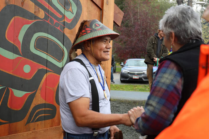 Tlingit master carver Wayne Price shakes hands with community members after the ceremony. Price has been a carver since 1971, and has carved dozens and dozens of totem over the decades. (Clarise Larson / Juneau Empire)