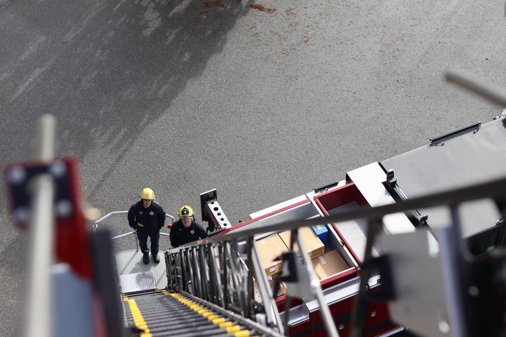 Jonson Kuhn / Juneau Empire 
Capital City Fire/Rescue engineer Peter Flynn and firefighter Connor Hoyt stand at the bottom of the department’s new truck ladder on Thursday, Oct. 6 during training operations at the Glacier Fire Station.