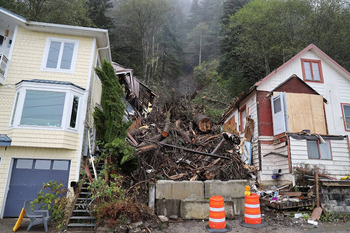 Clarise Larson/ Juneau Empire
Two cones and concrete barriers sit near the fallen trees and debris left over after a landslide occurred early last week. Officials determined in the aftermath of the event that the landslide occurred predominantly due to a large tree that fell and in the process pulled down mud and other debris with it as it slid down the hillside.