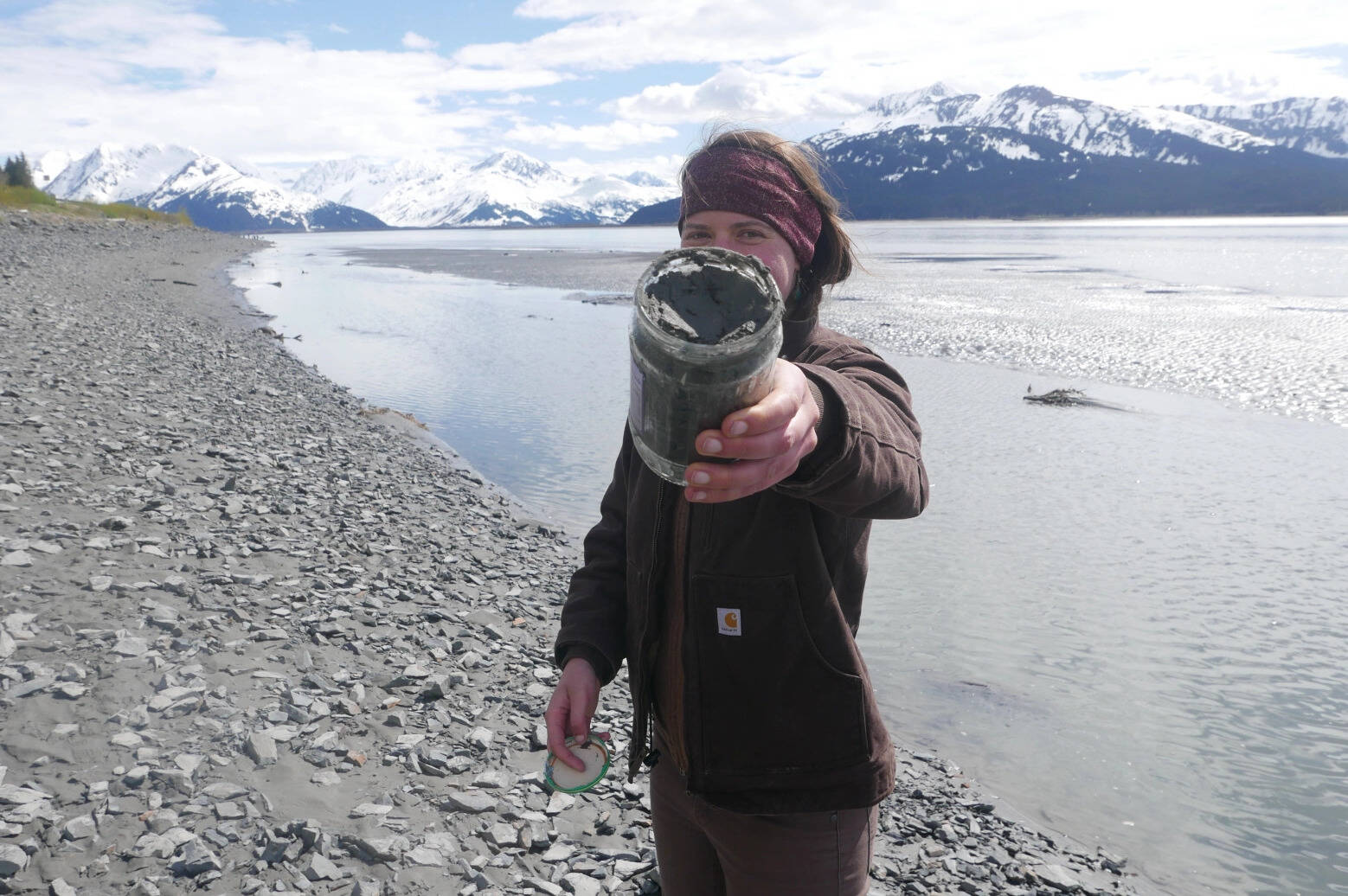 Kelsey Aho holds a jar of clay she collected while fishing for hooligan on Turnagain Arm near Anchorage in 2021. (Courtesy Photo / Kelsey Aho)