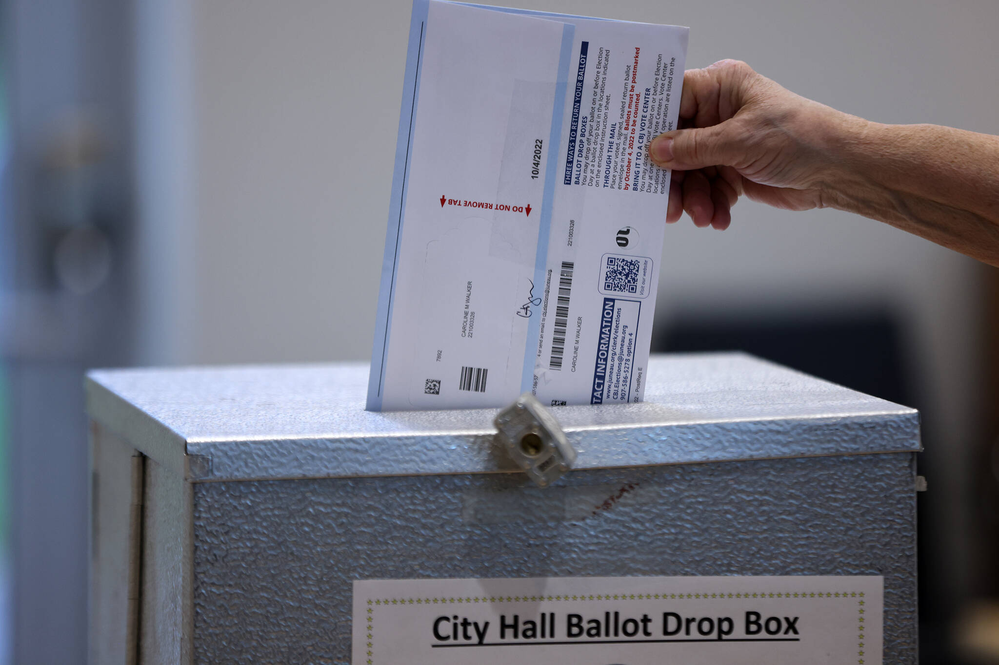 A ballot is placed in a ballot drop box on Tuesday, Oct. 4. (Ben Hohenstatt / Juneau Empire)