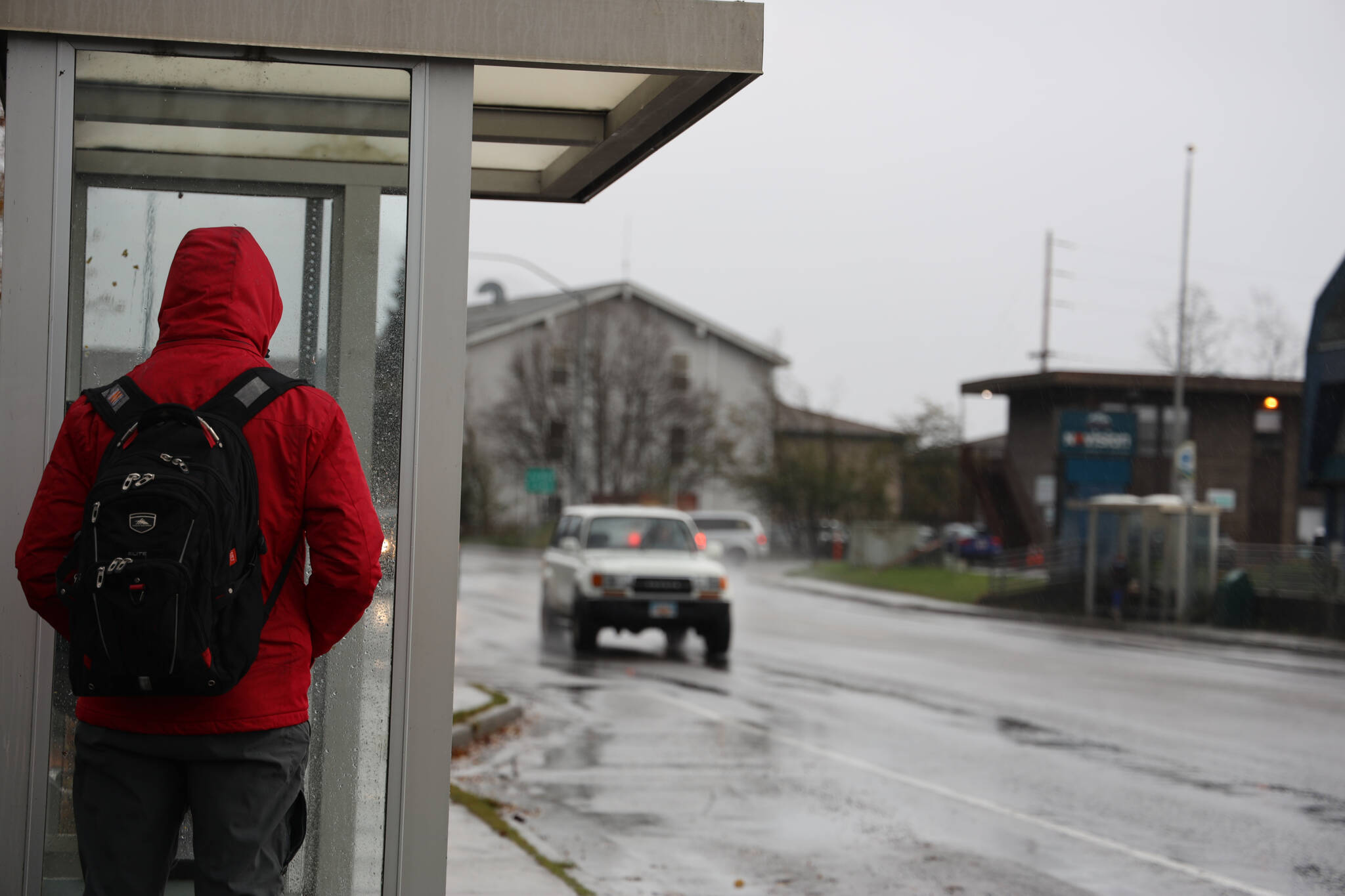 A person waits at a bus station in the Valley area as rain patters around them Thursday afternoon. Weather service expects the rain to end in the Juneau area overnight Thursday and another front to arrive again Friday night. (Clarise Larson / Juneau Empire)