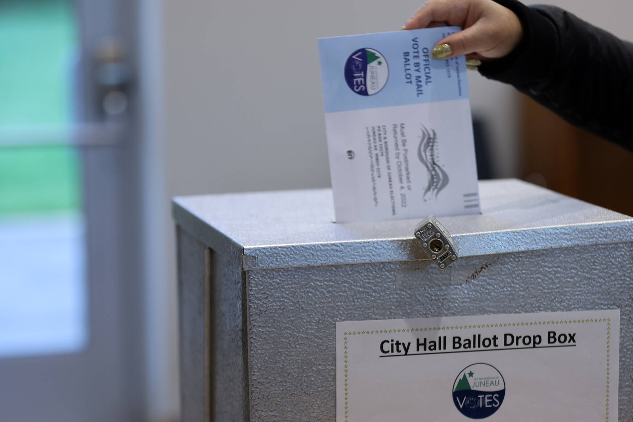 A ballot is placed in a drop box on Tuesday, Oct. 4, during the City and Borough of Juneau municipal election. Voters could cast ballots by mail, at voting centers located at City Hall and the Mendenhall Valley Public Library or at secure drop boxes at Don D. Statter Harbor and at the Douglas Public Library/ Fire Station. (Ben Hohenstatt / Juneau Empire File)
