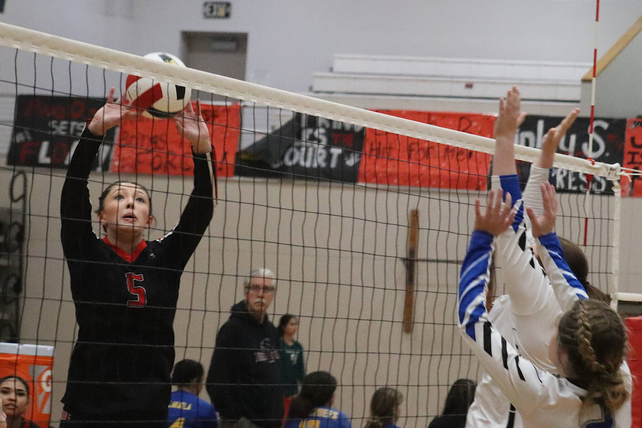 Gwen Nizich, a freshman at Juneau-Douglas Yadaa.at Kalé High School, taps the ball over the net on her home court during the Juneau Invitational Volleyball Extravaganza on Saturday. (Mark Sabbatini / Juneau Empire)