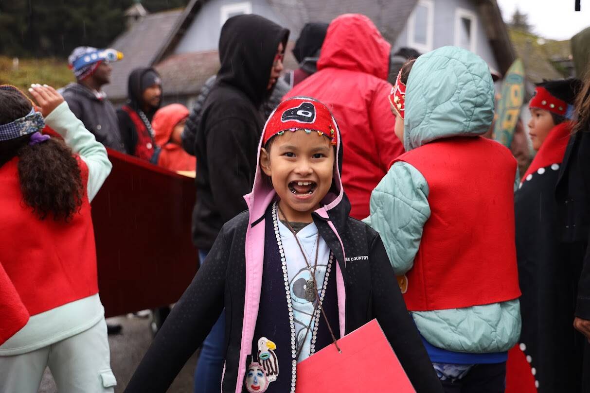 A young student from Chatham School District smiles in the crowd on Wednesday morning as residents walk down Front Street in Angoon to commemorate 140 years since since the U.S. Navy bombarded the village. (Clarise Larson / Juneau Empire)