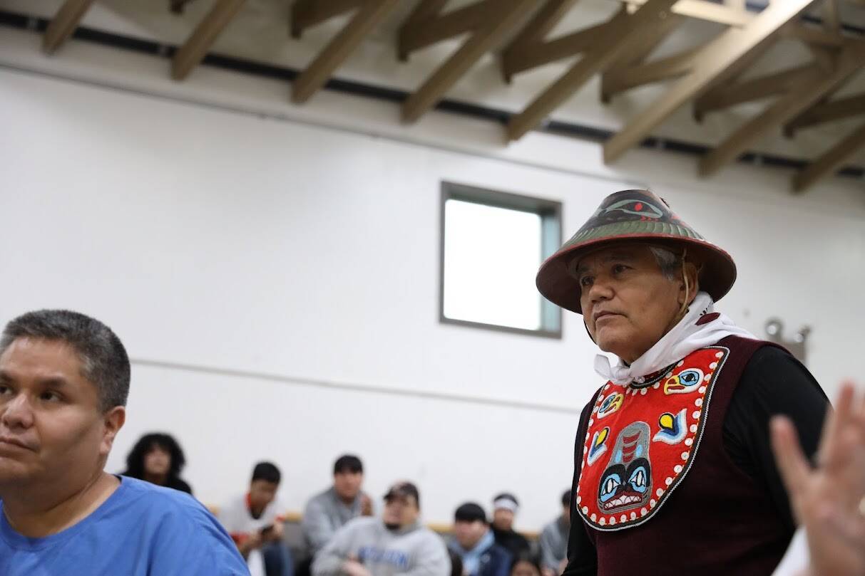 Tlingit master carver Wayne Price stands amid applause for his work during the commemoration ceremony. (Clarise Larson / Juneau Empire)