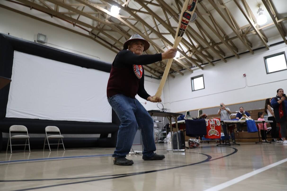 Tlingit master carver Wayne Price dances with a canoe paddle he was gifted during the commencement ceremony. Students gifted Price a painted wooden paddle they made for him as a gift to say thank you for all his time, effort and knowledge that he shared with them. (Clarise Larson / Juneau Empire)