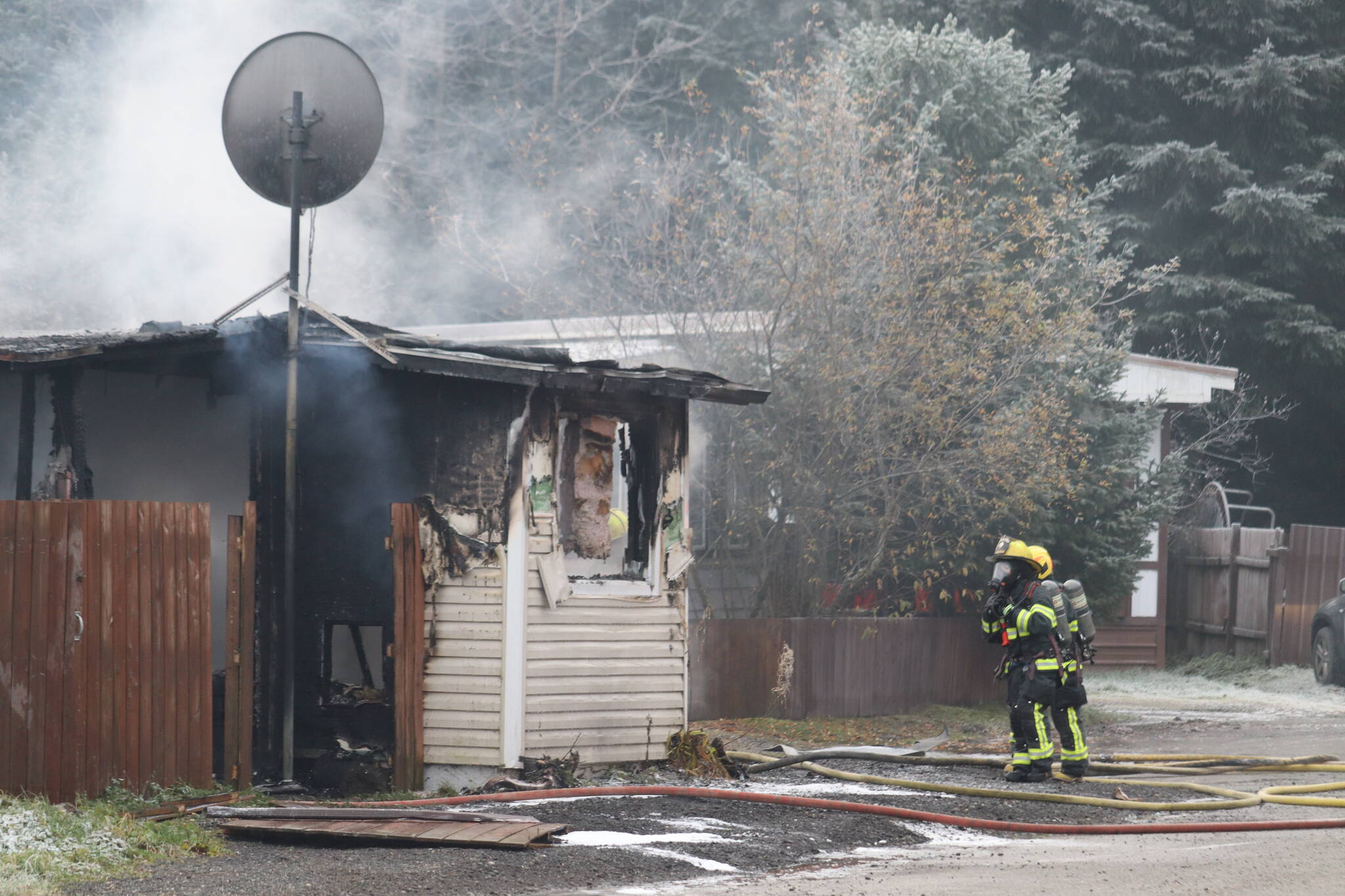 Firefighters working to contain flames Wednesday morning within a trailer in the 9900 block of Stephen Richards Memorial Drive and CCFR determined that the trailer is a total loss based on damages. (Jonson Kuhn / Juneau Empire)