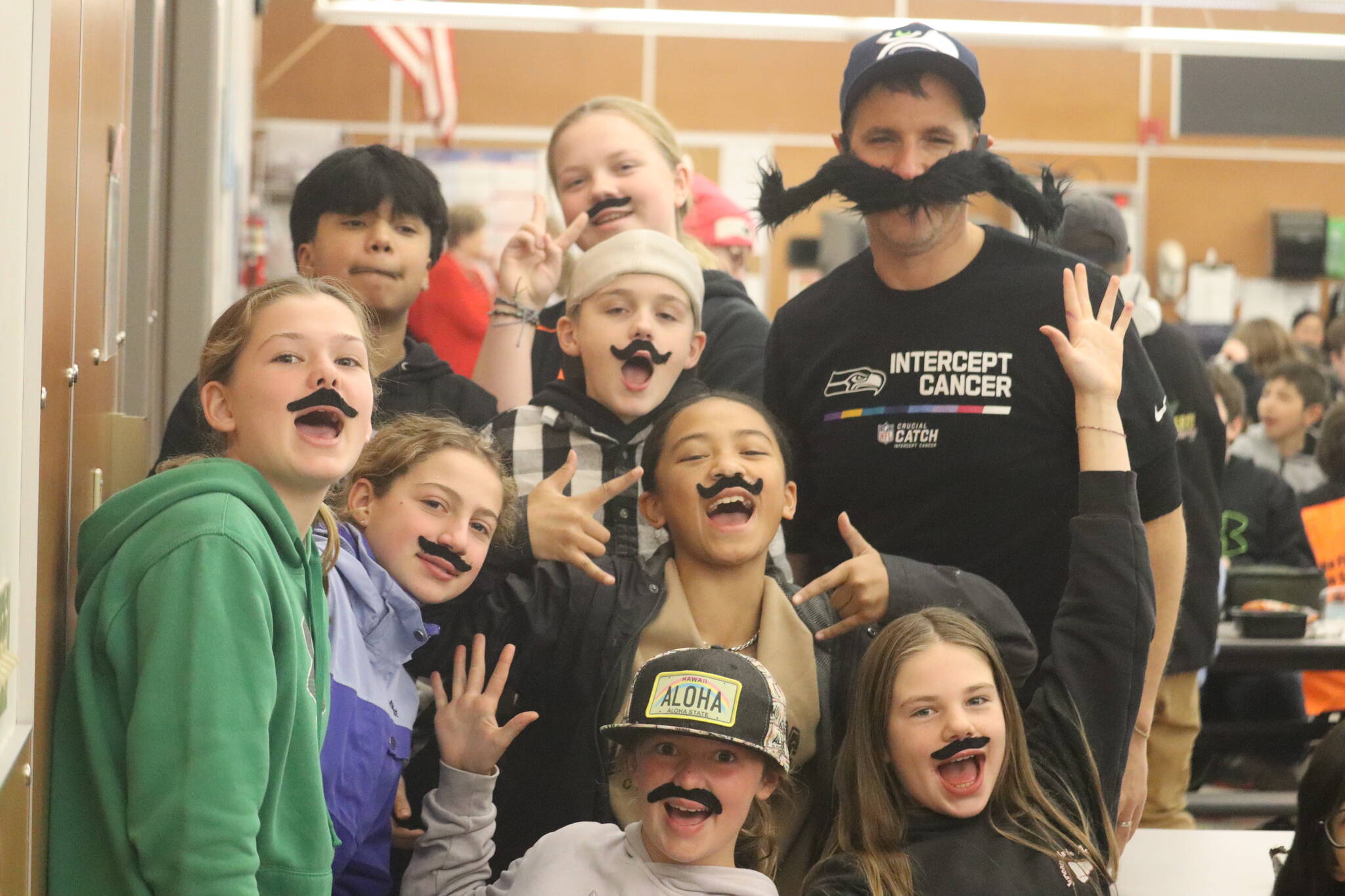 Floyd Dryden Middle School teacher James White poses with seventh graders with mustaches as a way of recognizing Movember, a movement raising awareness of men’s health issues throughout the month of November. (Jonson Kuhn / Juneau Empire)
