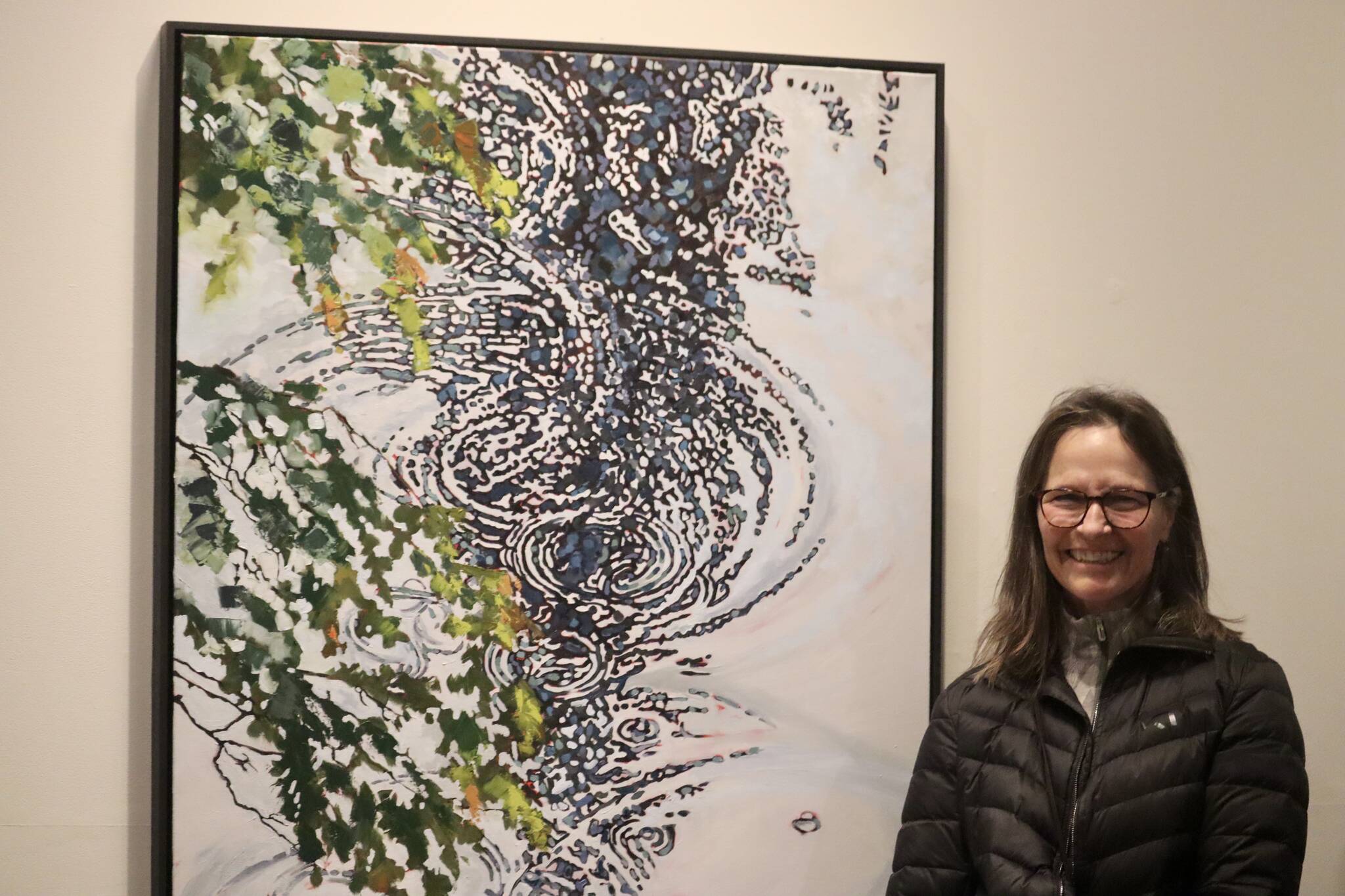 Kerry Kirkpatrick stands by her painting ‘Ripple,’ one of many paintings included within her latest exhibit “Capturing the Light” on display at the Juneau-Douglas City Museum from Nov. 4 through Nov. 26. (Jonson Kuhn / Juneau Empire)