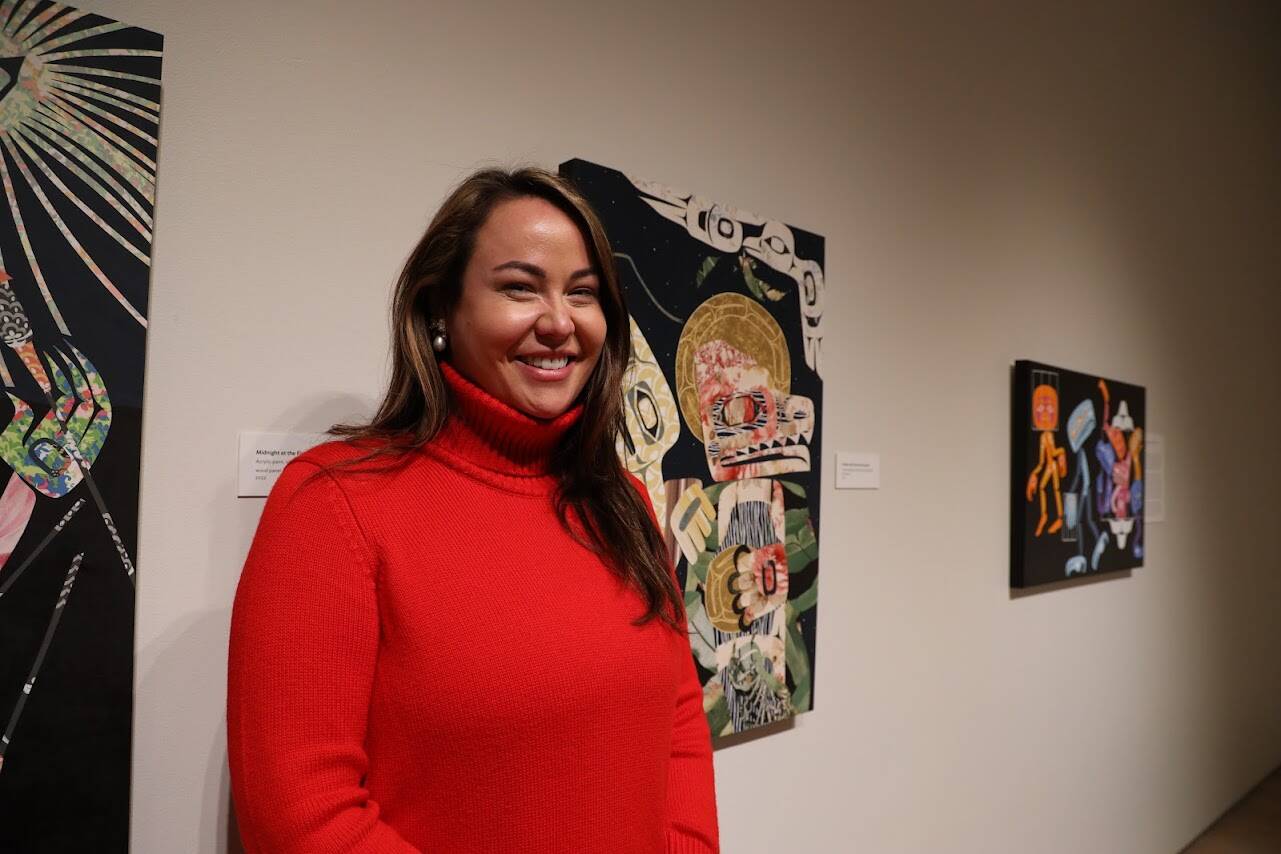 Alison Bremner Nax̲shag̲eit smiles in front of some of her pieces displayed in her new solo exhibit “Midnight at the Fireworks Stand” featured at the Alaska State Museum. Bremner’s 17 piece-collection of contemporary art depicts different stories and aspects of Tlingit and Indigenous life that often go unnoticed, through bright colors, unusual objects and humor.(Clarise Larson / Juneau Empire)