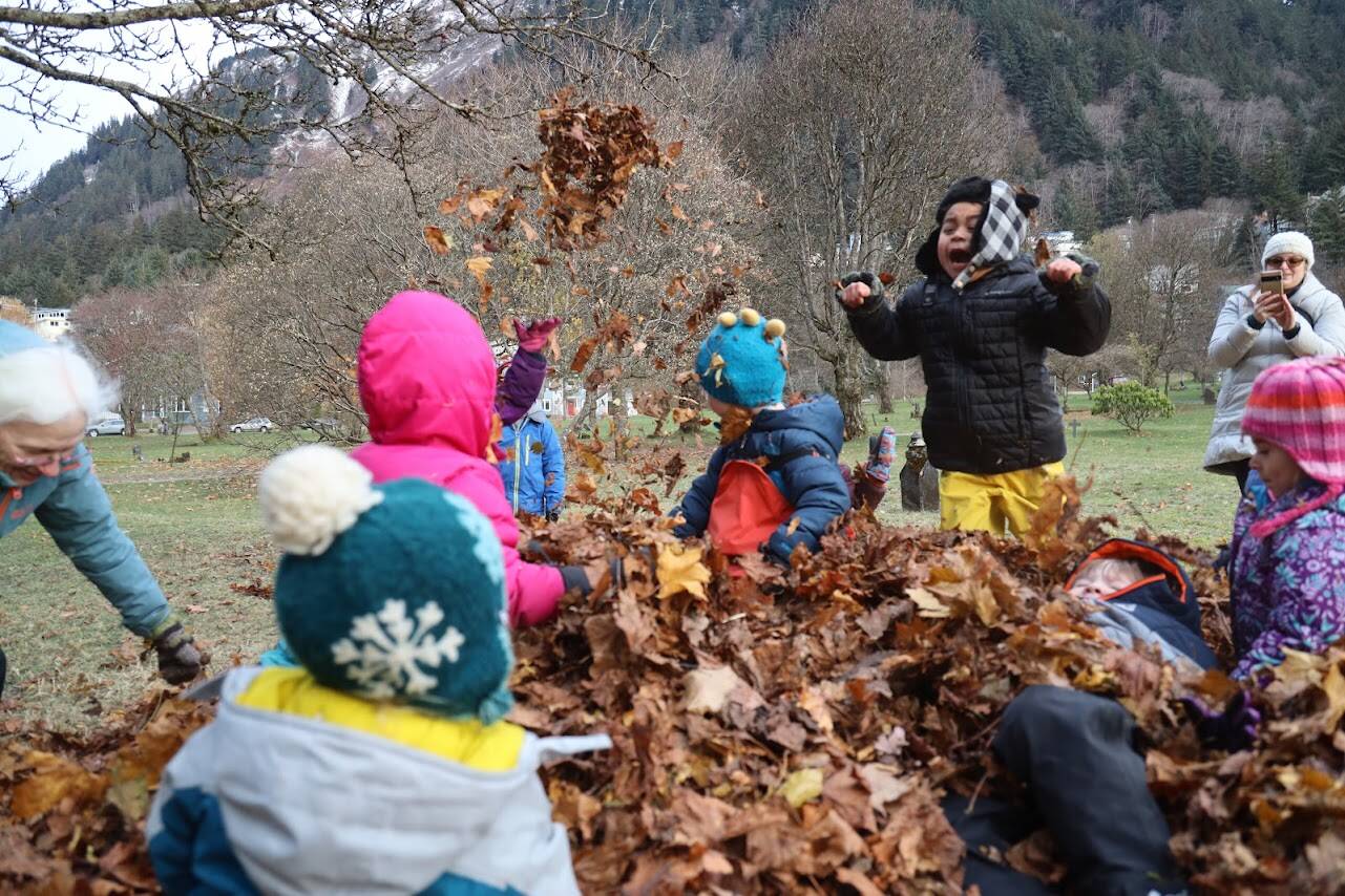 KinderReady Preschool students from Harborview Elementary frolic in a pile of dried leaves at Evergreen Cemetery on Tuesday. The leaf jump is an annual event organized by Linda Torgerson and has been happening in Juneau for around 25 years. (Clarise Larson / Juneau Empire)